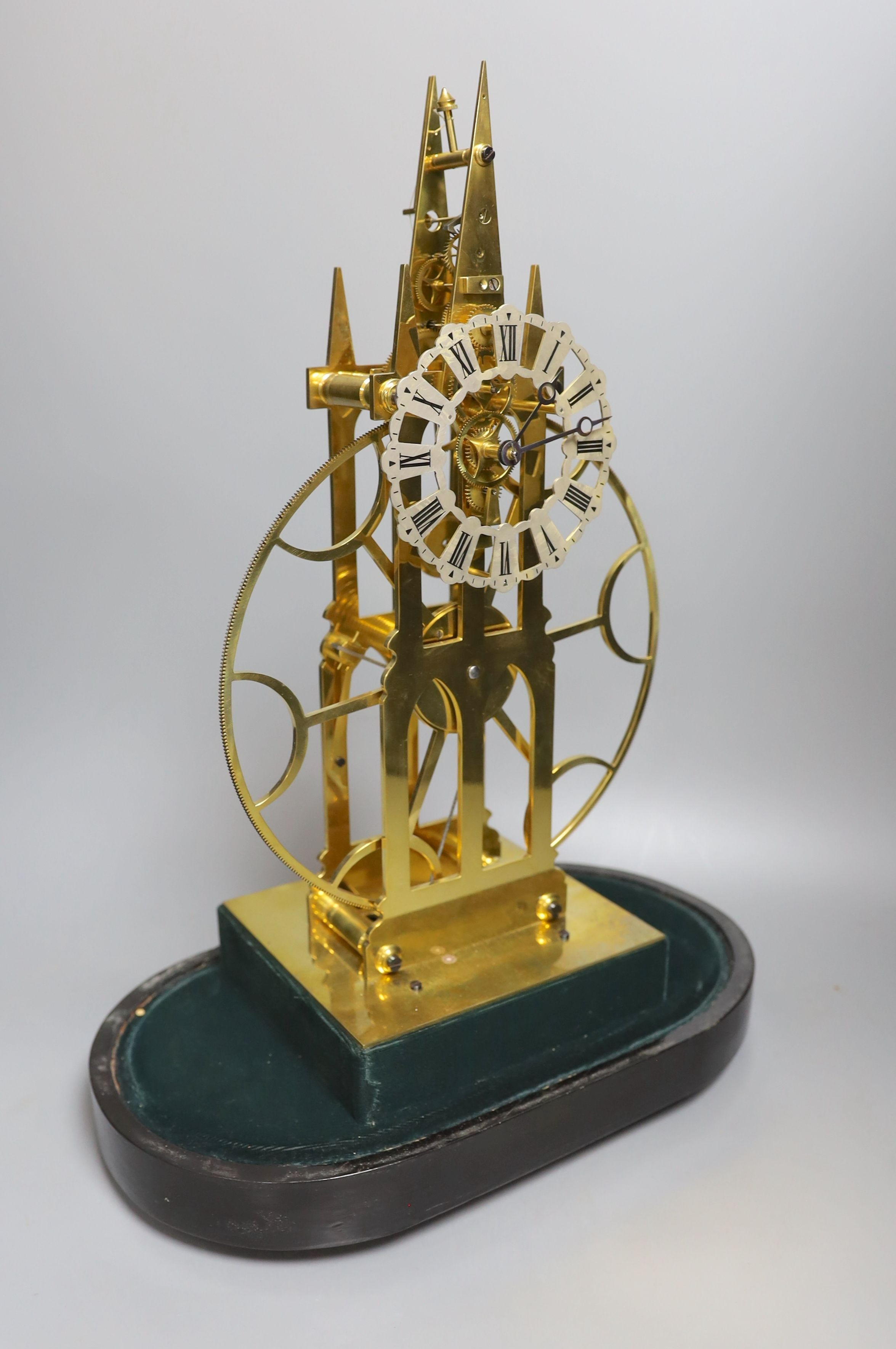 A brass skeleton fusee mantel timepiece, with large wheel, under glass dome on stand, 49cms high.